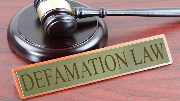 Illustration of a legal gavel and scales with the text 'Defamation Law' written prominently, symbolizing legal concepts.